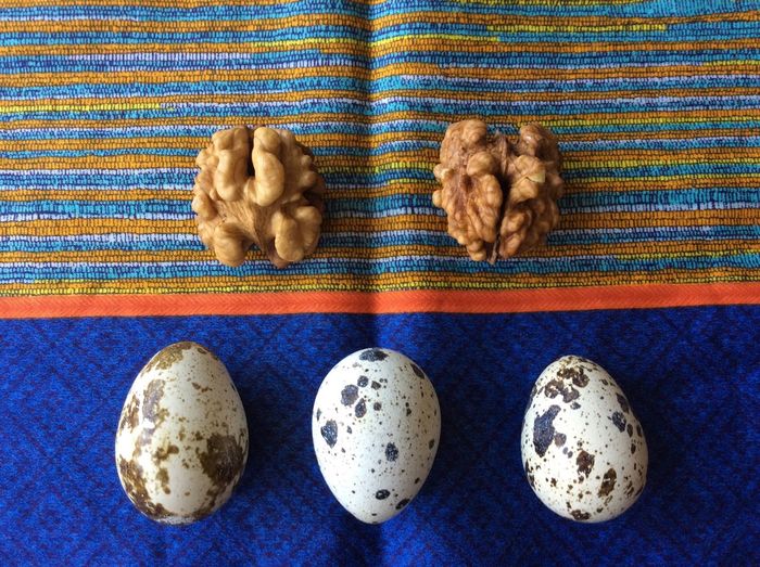 Directly above shot of quail eggs and walnuts on tablecloth