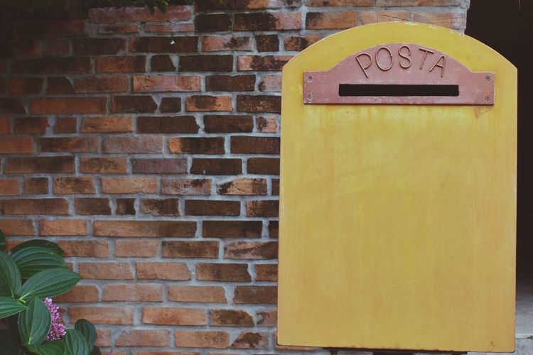 Close-up of mailbox on brick wall