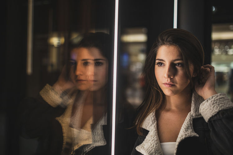 Young woman looking through glass window