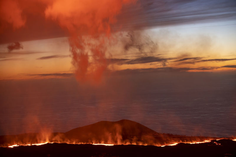 Dramatic scenery of burning lava flowing on rocky mountain slope in la palma island at night