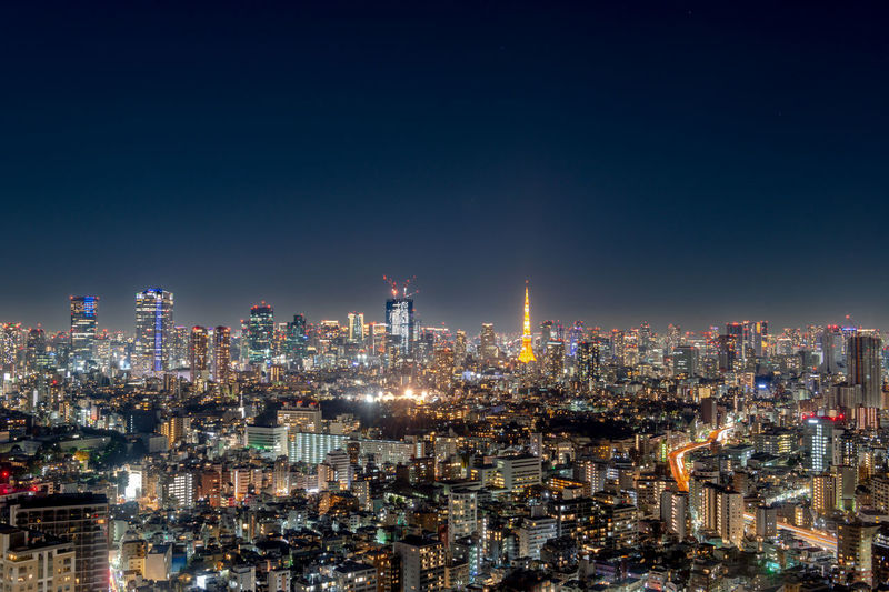 Illuminated cityscape against sky at night