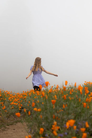 Low angle view of woman climbing on field against clear sky