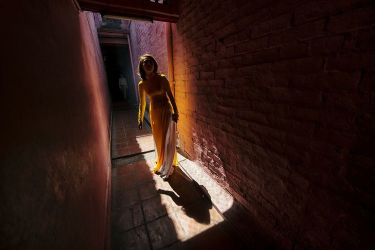 Full length of woman standing in alley