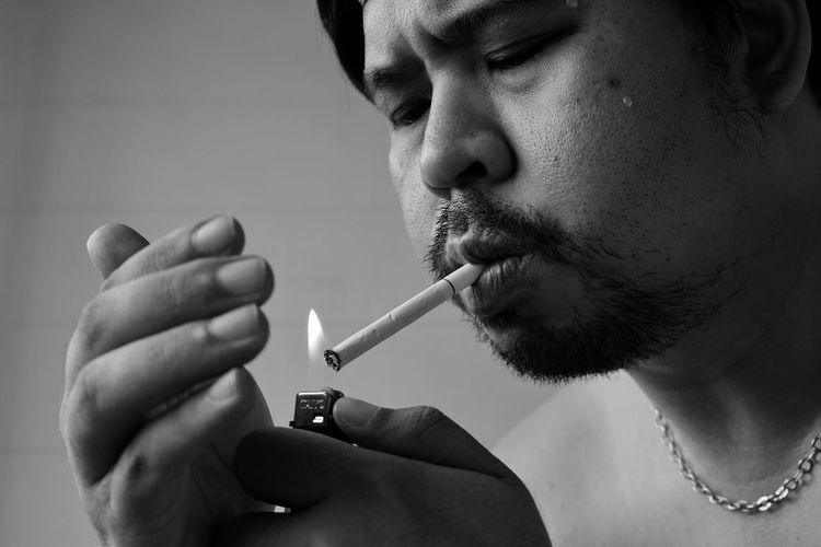 Close-up of man igniting cigarette
