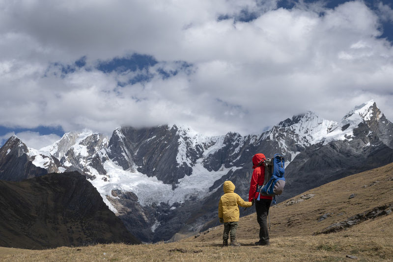 A mom and her son hiking along the huayhuash circuit at high mountains