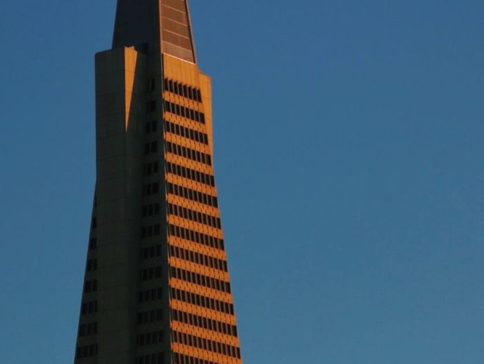 Low angle view of modern buildings against clear blue sky