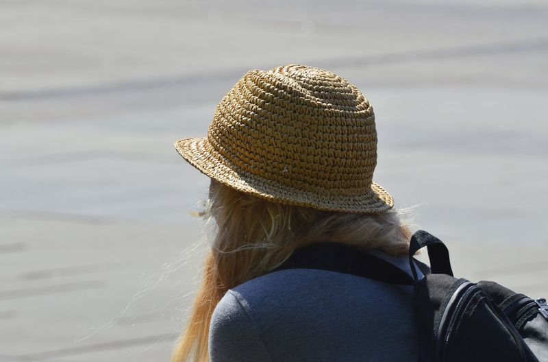 Woman wearing hat at beach on sunny day