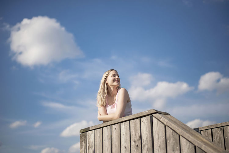 Low angle view of beautiful woman standing against sky