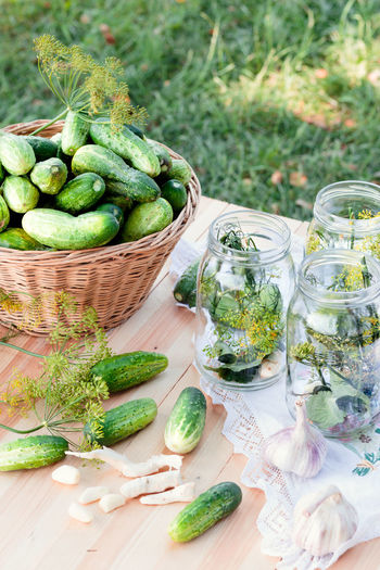 Jars and fresh cucumbers on table
