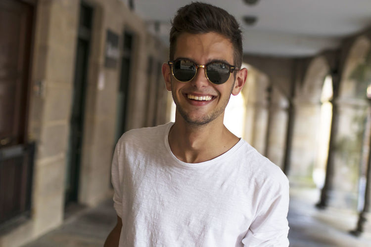 Portrait of young man wearing sunglasses standing outdoors