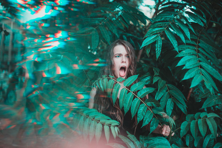 Young woman standing amidst plants