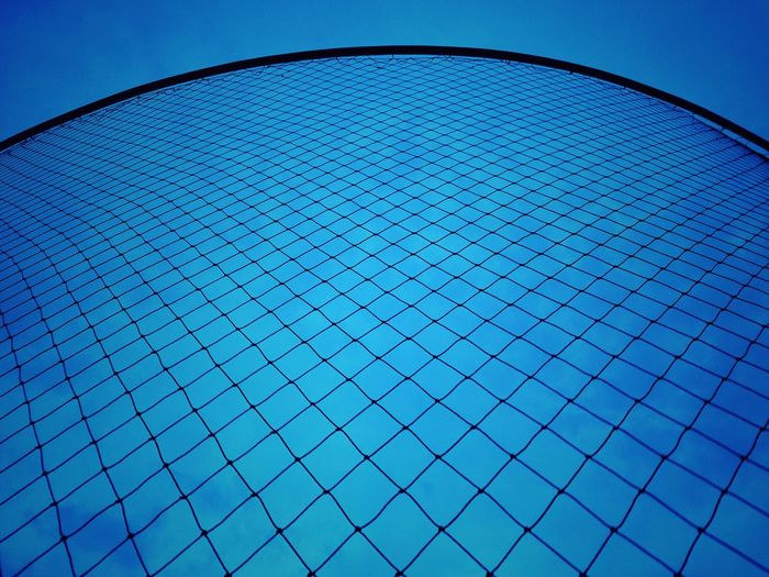 Low angle view of grid pattern against clear blue sky