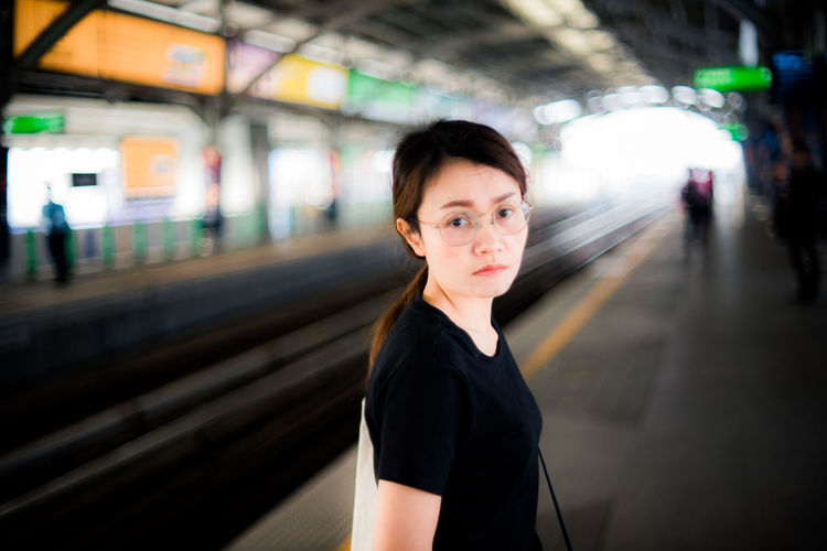 Portrait of woman standing at railroad station