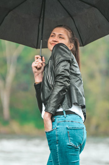 Woman holding umbrella while standing on rainy day