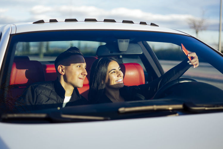 Portrait of a smiling young couple sitting in car