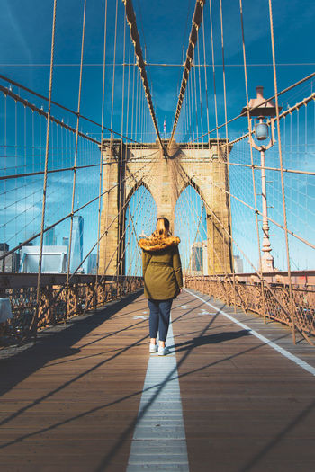 Rear view of woman walking on brooklyn bridge