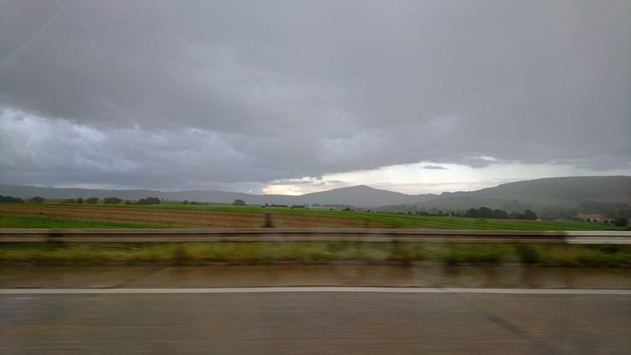 Road by landscape against sky