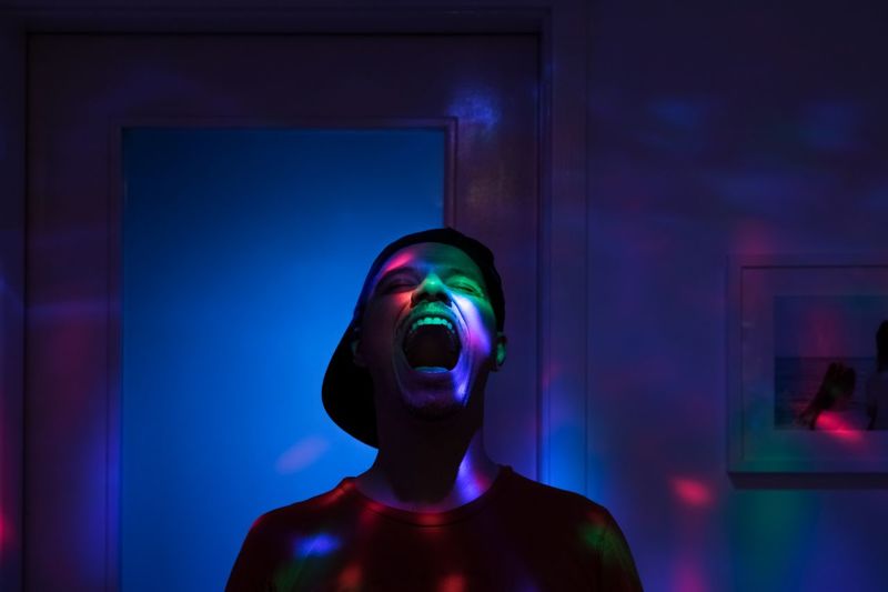 Man shouting while standing in illuminated room