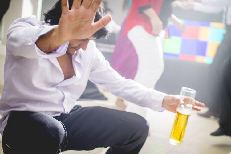 Close-up of man holding mobile phone while sitting on table