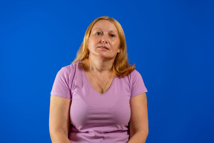 Portrait of woman against blue background