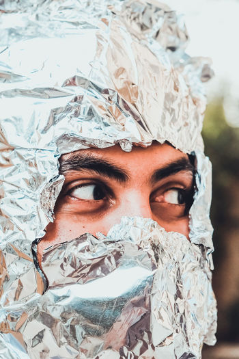 Close-up of man with face covered by aluminum foil