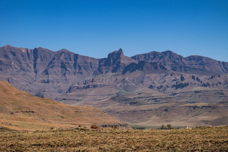 Scenic view of rhino peak of drakensberg mountains against clear blue sky
