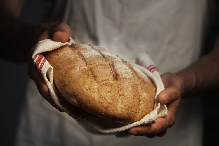 Midsection of person holding bread