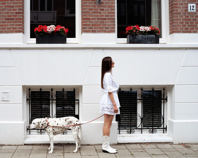 Full length of woman with dog on wall