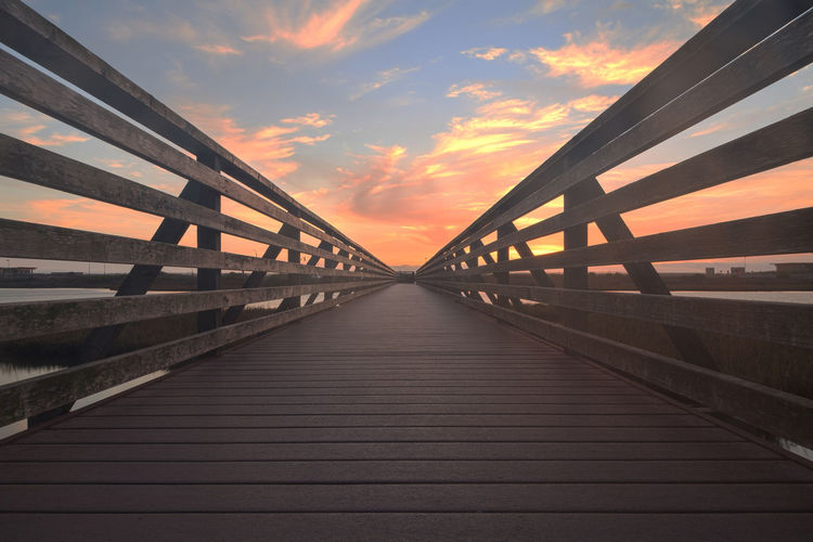 Pathway of bridge at sunset