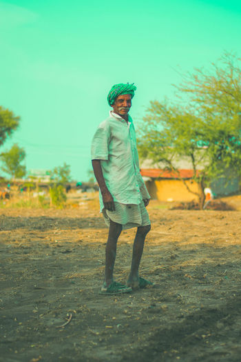 Full length of man standing on field against sky