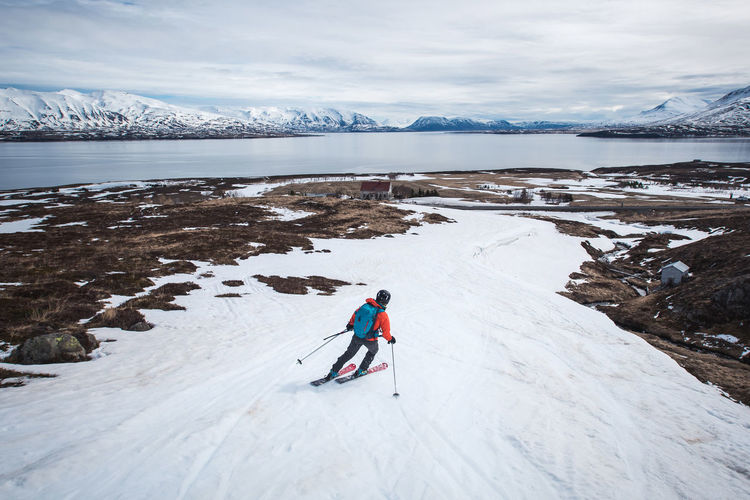 Woman skiing towards the ocean in iceland