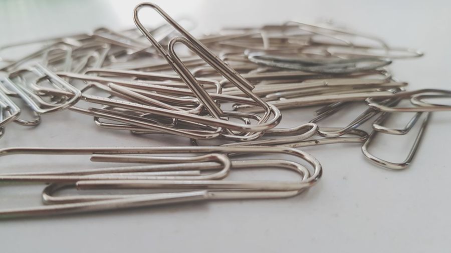 Close-up of paper clips over white background