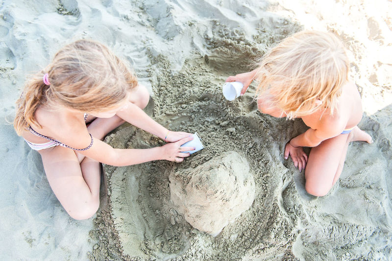 High angle view of sibling playing on beach
