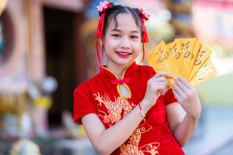 Portrait of smiling girl holding envelopes