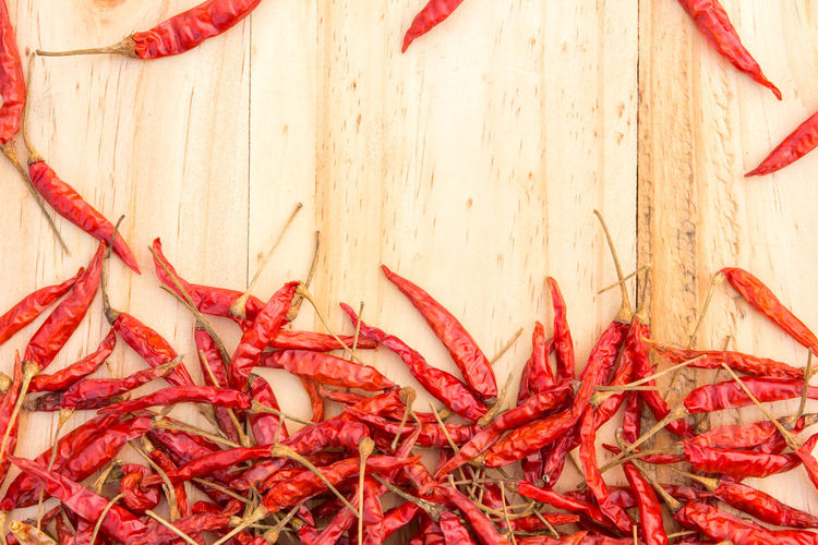 High angle view of red chili peppers on wood