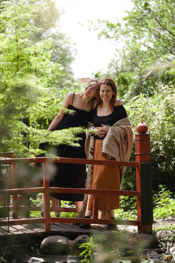 Happy ginger hair woman with friend in well-groomed park or garden. support and healthy way of life