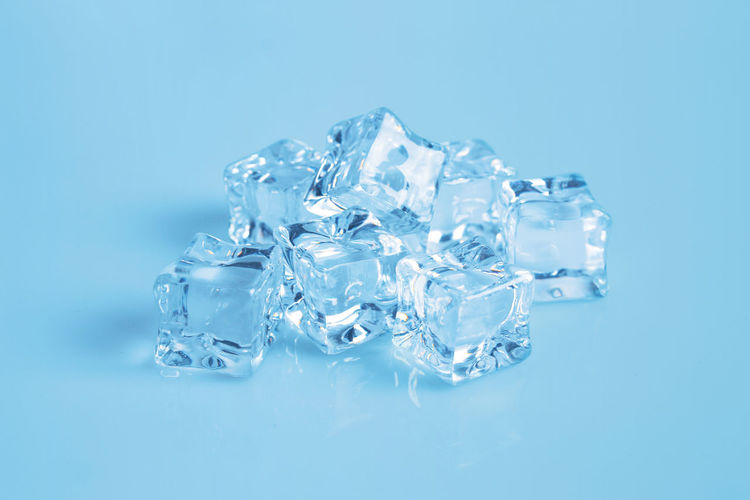 Stack of ice cubes on blue background