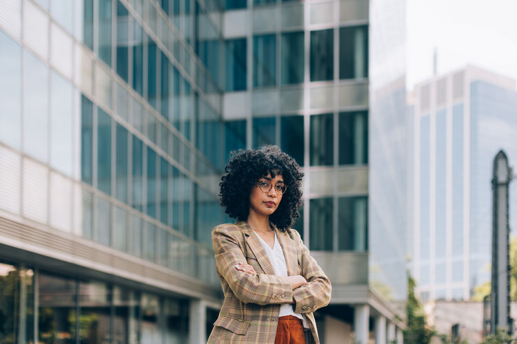 Photograph of fashionable female businesswoman among the buildings of the financial district