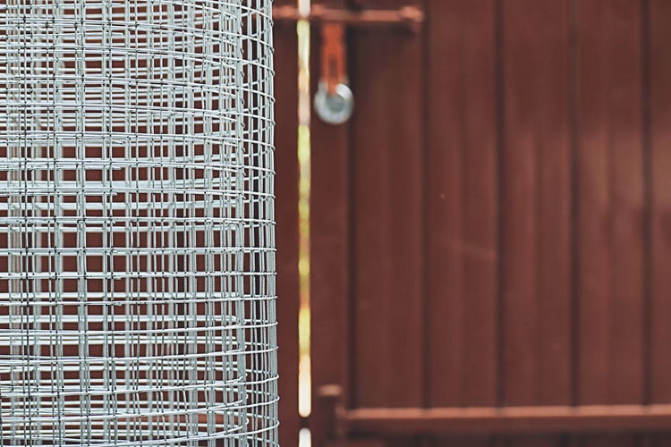 Close-up of birdcage against closed door