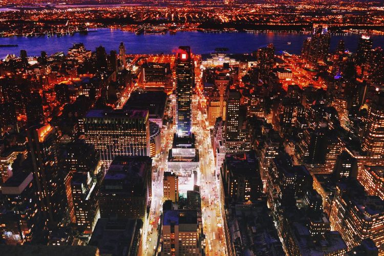 Illuminated cityscape by hudson river at night