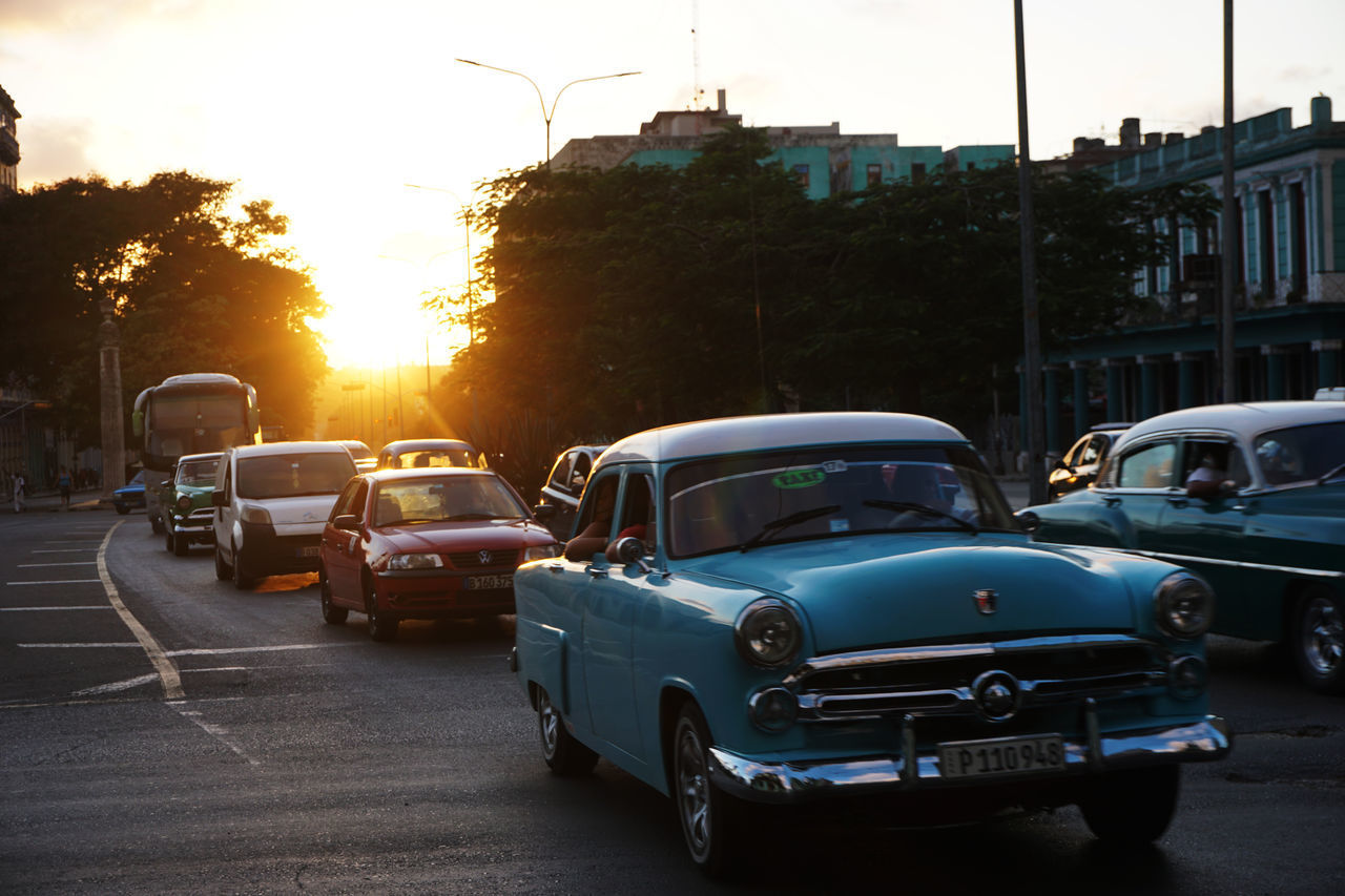 CARS ON STREET IN CITY DURING SUNSET