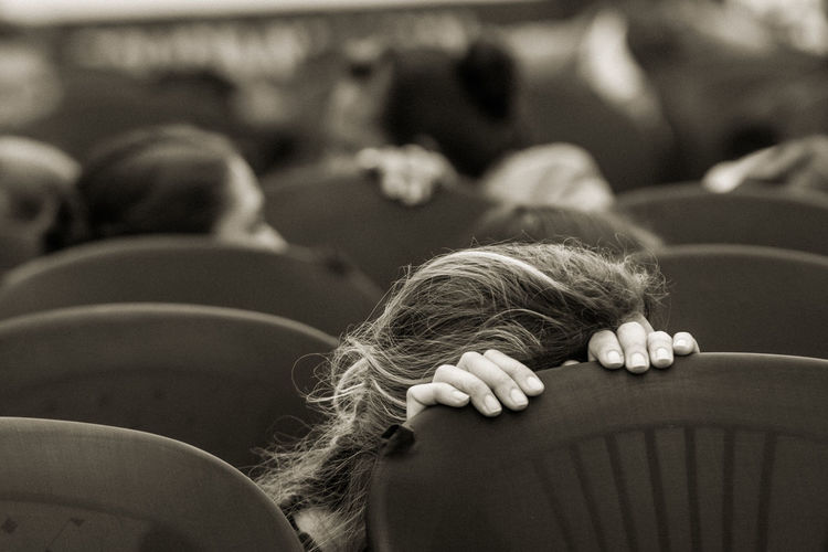Woman hiding behind a chair