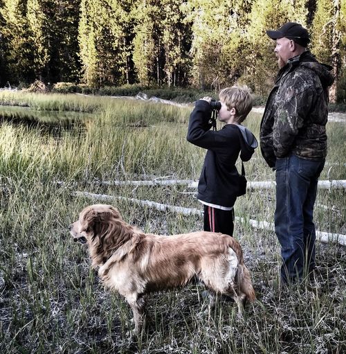 Father and son on a field with dog