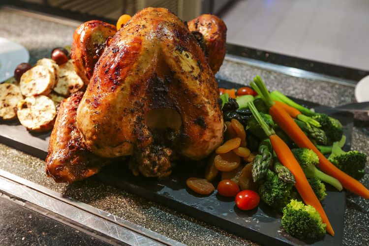 Close-up of roasted chicken on slate