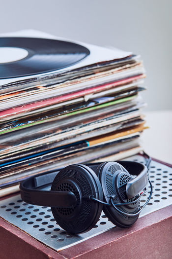 High angle view of records with headphones on table against gray background