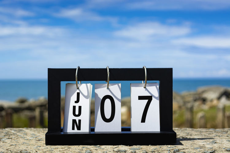 Jun 07 calendar date text on wooden frame with blurred background of ocean. calendar date concept.