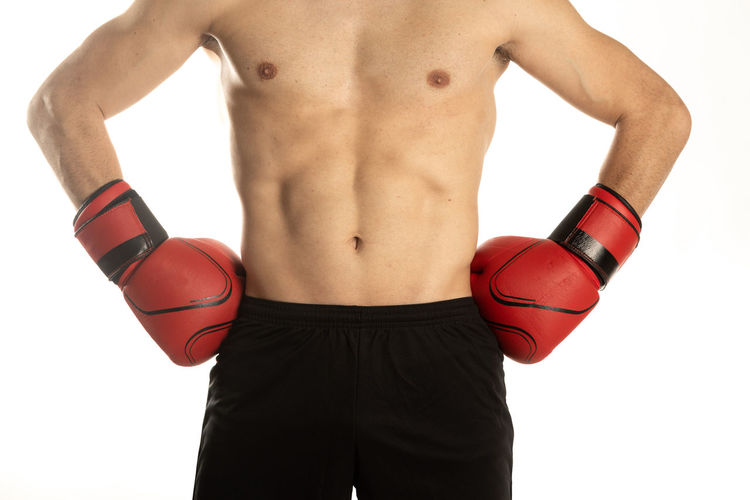 Midsection of shirtless man standing against white background