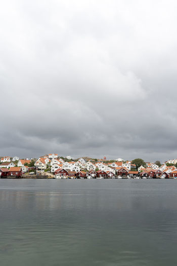 Scenic view of sea by townscape against sky in sweden