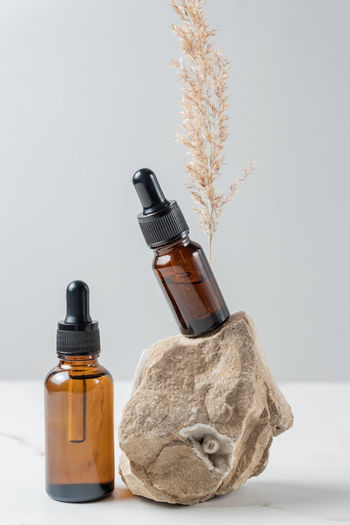 Anti aging serum with collagen and peptides in dark glass bottles with dropper on gray background