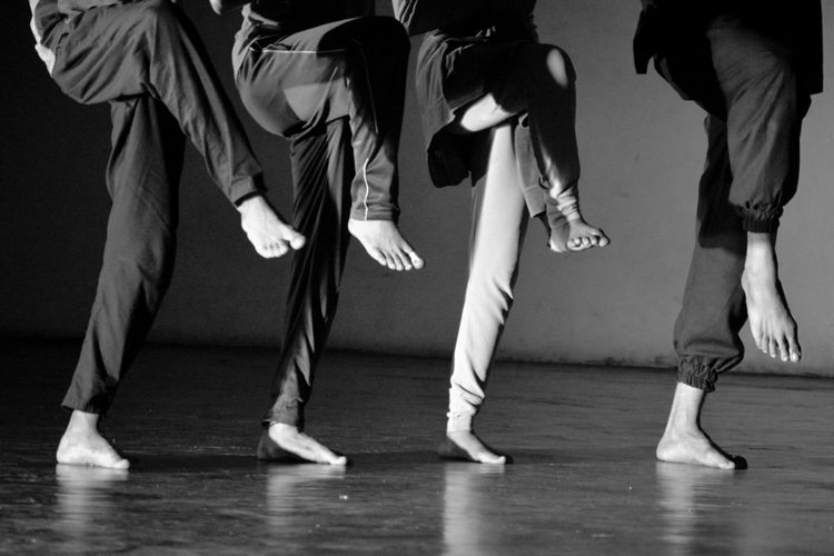 Low section of people walking on hardwood floor